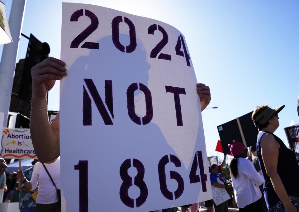 Demonstrators hold signs protesting the 1864 near-total abortion ban in Scottsdale, Arizona, on April 14.