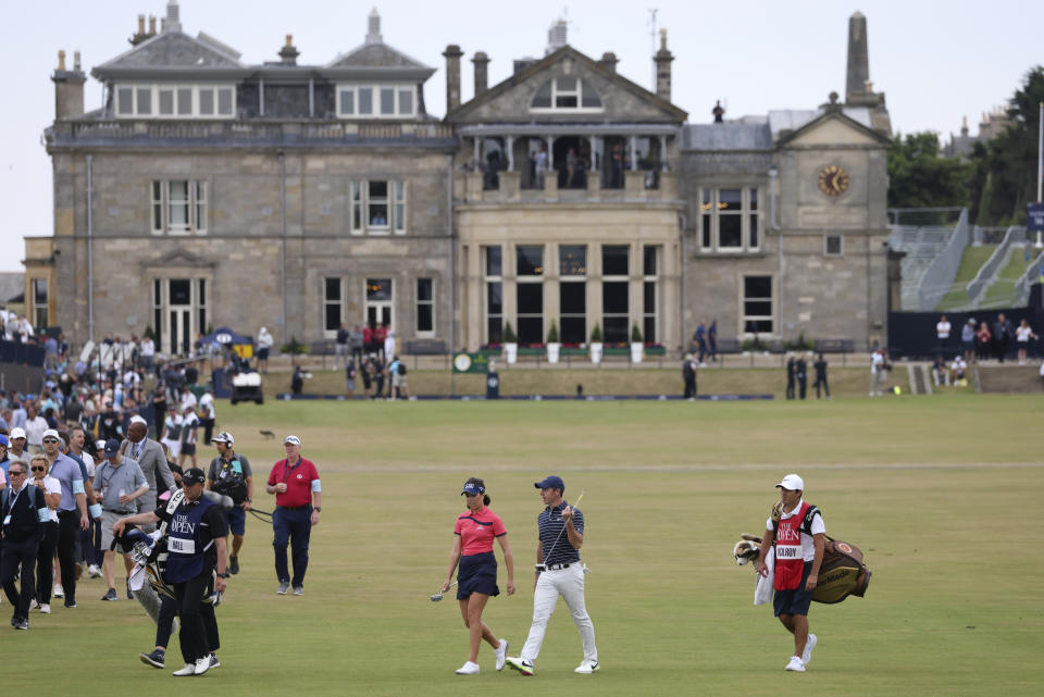 Northern Ireland's Rory McIlroy and England's Georgia Hall walk across the first fairway during a 'Champions round' as preparations continue for the British Open golf championship on the Old Course at St. Andrews, Scotland, Monday July 11, 2022. The Open Championship returns to the home of golf on July 14-17, 2022, to celebrate the 150th edition of the sport's oldest championship, which dates to 1860 and was first played at St. Andrews in 1873. (AP Photo/Peter Morrison)