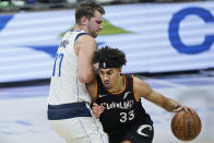 Dallas Mavericks' Willie Cauley-Stein (33) drives against Dallas Mavericks' Luka Doncic (77) during the first half of an NBA basketball game Sunday, May 9, 2021, in Cleveland. (AP Photo/Tony Dejak)