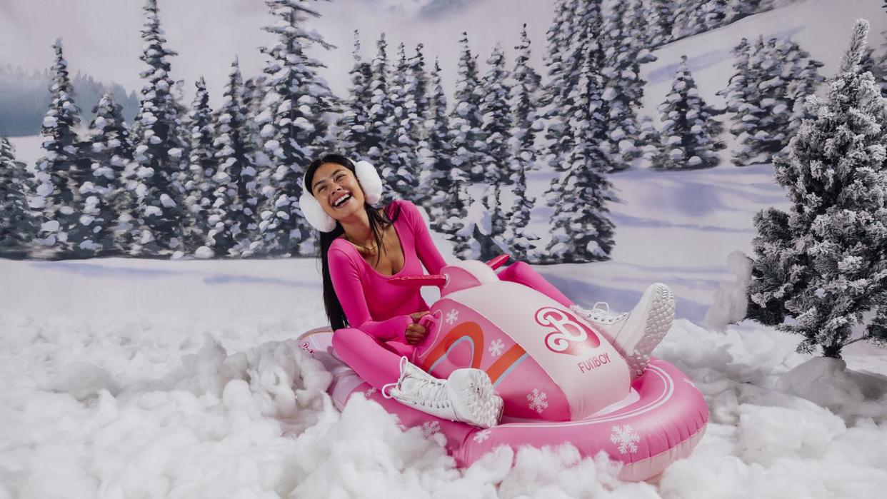 a person sitting on a pink snowmobile in the snow