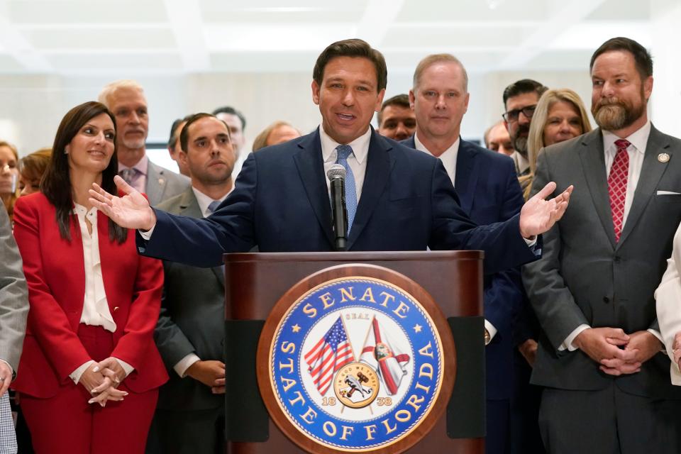 Surrounded by lawmakers, Florida Gov. Ron DeSantis speaks at the end of a legislative session, Friday, April 30, 2021, at the Capitol in Tallahassee, Fla.