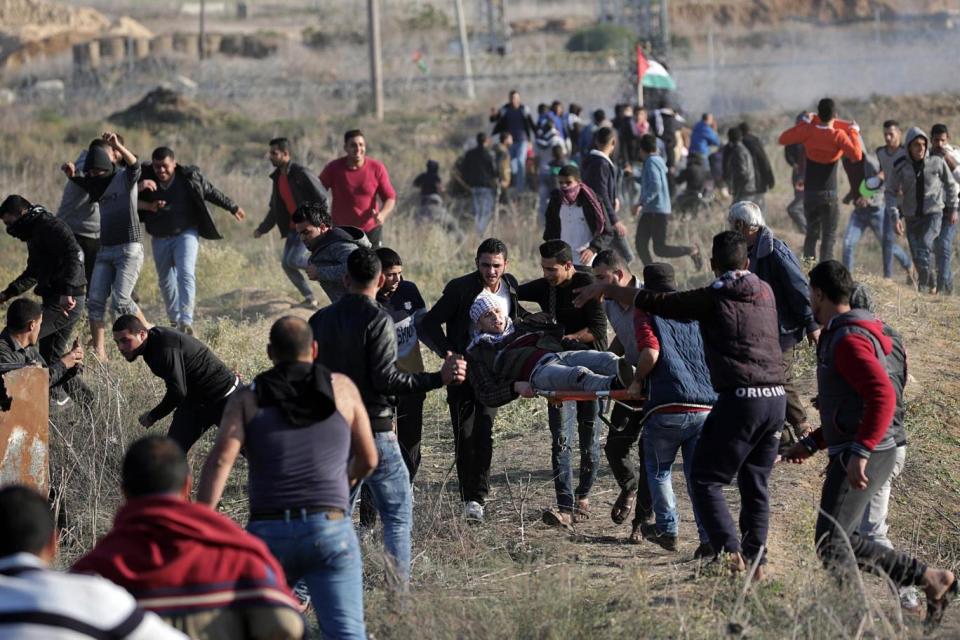 Palestinian protesters carry a wounded young during a protest against US President decision to recognise Jerusalem as the capital of Israel (EPA)