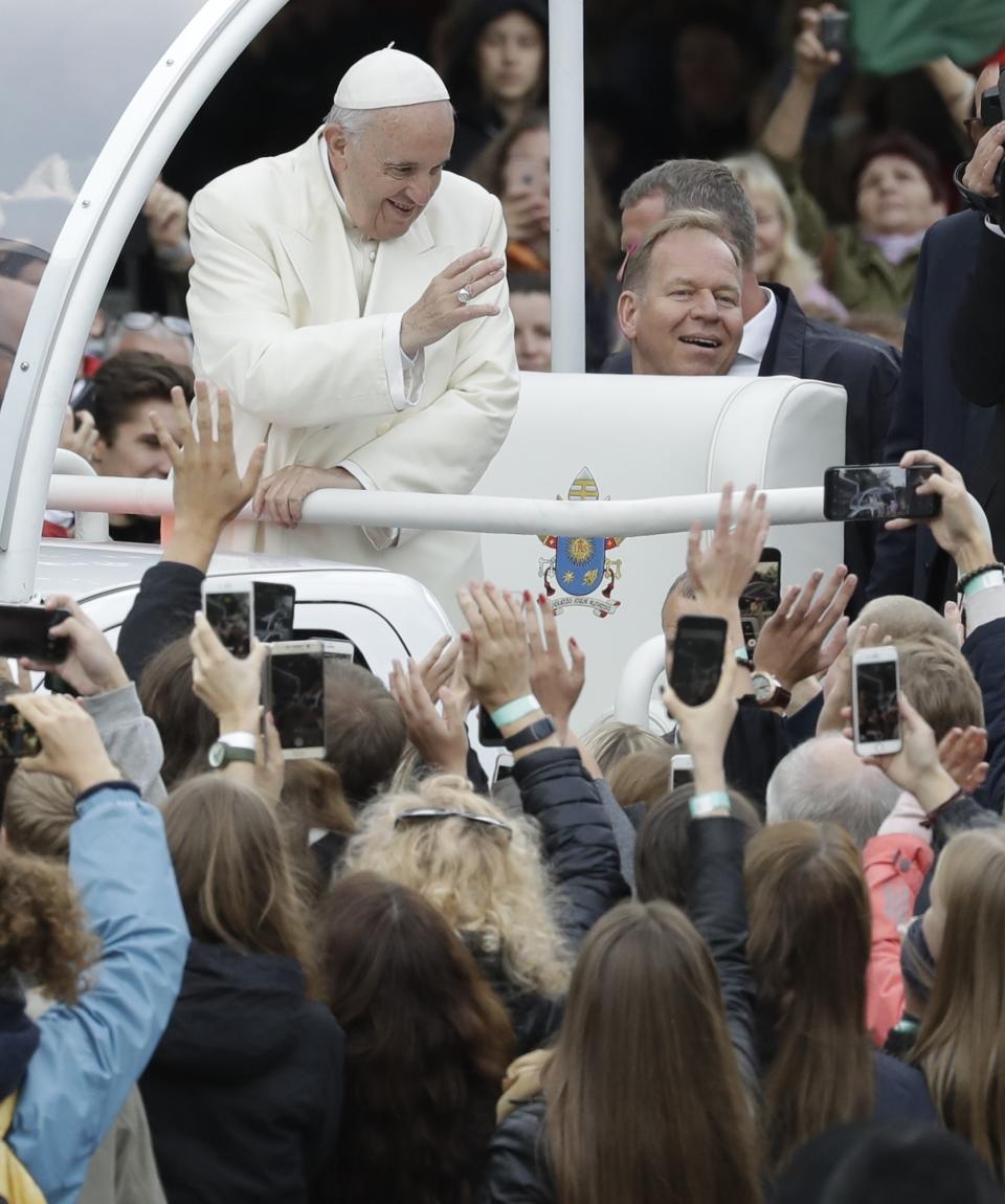 Pope Francis greets faithful as he arrives for a meeting with youths in Vilnius, Lithuania, Saturday, Sept. 22, 2018. Pope Francis begins a four-day visit to the Baltics amid renewed alarm about Moscow's intentions in the region it has twice occupied. (AP Photo/Andrew Medichini)