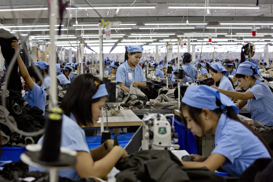 FILE - In this Sept. 29, 2015, file photo, workers in the Great Forever factory stitch clothes in the Hlaing Tharyar industrial zone outside Yangon, Myanmar. Garment workers in Myanmar are urging major international brands to denounce the recent military coup there and put more pressure on factories to protect workers from being fired or harassed - or worse arrested and killed for participating in protests. (AP Photo,File)