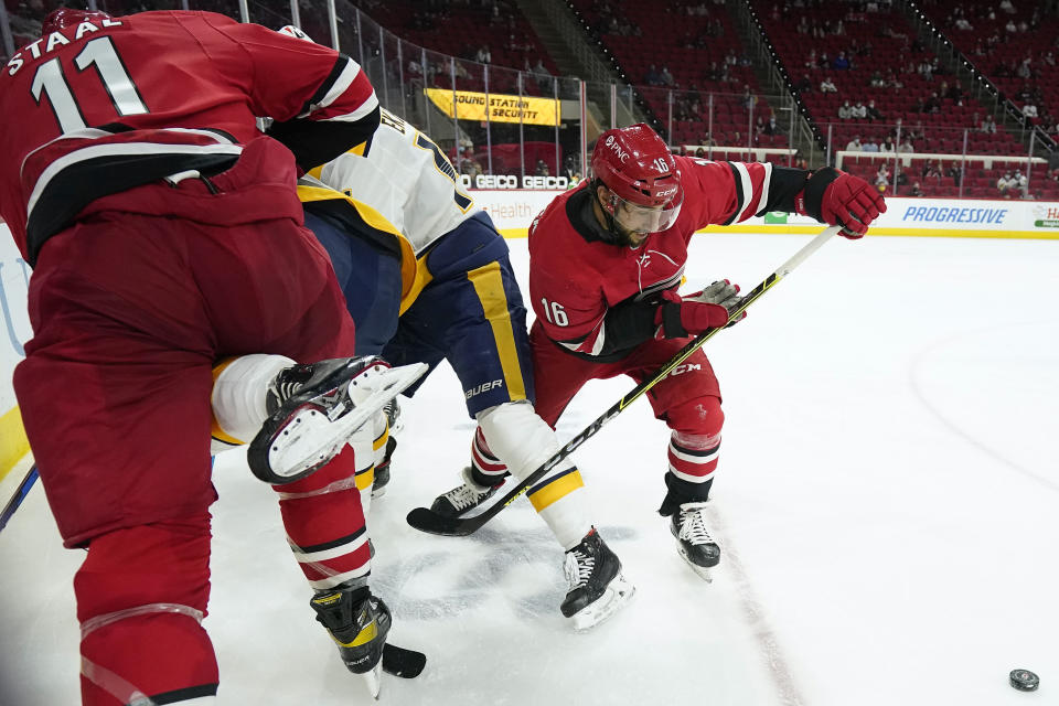 Carolina Hurricanes center Vincent Trocheck (16) and center Jordan Staal (11) struggle with Nashville Predators defenseman Mattias Ekholm during the second period of an NHL hockey game in Raleigh, N.C., Saturday, April 17, 2021. (AP Photo/Gerry Broome)