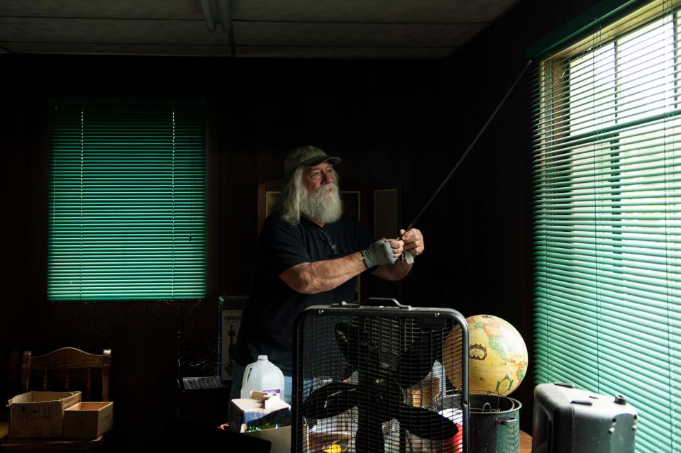 Paul Evans Pedersen, a Pinelands author, musician and jewelry maker, closes the blinds inside his workshop Tuesday, May 24, 2022 in Malaga, NJ.