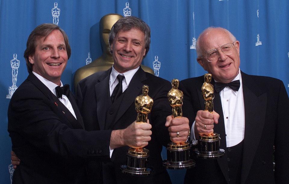 FILE - In this Sunday, March 25, 2001 file photo, from left: Douglas Wick, David Franzoni and Branko Lustig hold their Oscars backstage at the Shrine Auditorium in Los Angeles, after "Gladiator" was honored as best picture of the year by the Academy of Motion Pictures Arts & Sciences. Lustig, an Oscar-winning Croatian film producer and Holocaust survivor, has died at 87. The Yad Vashem center in Jerusalem said Lustig died Thursday, Nov. 14, 2019 in Zagreb, the capital of his native Croatia. Lustig is best known for winning Academy Awards for Best Picture for Steven Spielberg’s “Schindler's List” and for Ridley Scott’s “Gladiator.” (AP Photo/Richard Drew, file)