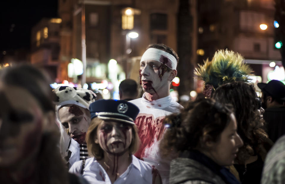  Israelis dressed as a zombies takes part in the customary 'Zombie Walk' in the city of Tel Aviv, on the eve of the Jewish holiday of Purim, late on March 15, 2014. The carnival-like Purim holiday is celebrated with parades and costume parties to commemorate the deliverance of the Jewish people from a plot to exterminate them in the ancient Persian empire 2,500 years ago, as described in the Book of Esther. AFP PHOTO/DAVID BUIMOVITCH        (Photo credit should read DAVID BUIMOVITCH/AFP/Getty Images)