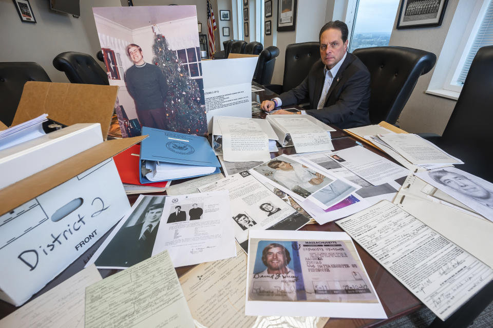 U.S. Marshal Peter J. Elliott poses for a photo on Dec. 16, 2021 at the Carl B. Stokes U.S. Courthouse in Cleveland with items related to a 1969 bank robbery. After more than 50 years, Elliott announced that they had closed the case on one the city's biggest bank robberies. Ted Conrad pulled off the 1969 robbery and had been living in Boston under a new name until his death last May, Elliott said. The U.S. Marshals Service is now piecing together how he managed to create new life while evading authorities. His stunned friends in Boston say he was a devoted family man and one of the nicest and most honorable people they'd ever known. (AP Photo/Ken Blaze)