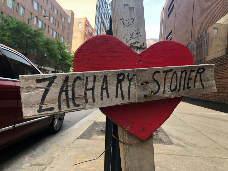 In this May 22, 2019 photo, a makeshift cross marking the spot where Zachary Stoner was killed on May 30, 2018, in a drive-by shooting in downtown Chicago. Chicago police documents obtained by The Associated Press show investigators believe they solved the 2018 killing of a gangland journalist known as “ZackTV” but that prosecutors declined to prosecute. Police never announced arrests in the downtown shooting of Zachary Stoner. But the documents say five “Perry Avenue” gang members were arrested within a year of the killing on probable cause of murder. (AP Photo/Michael Tarm)