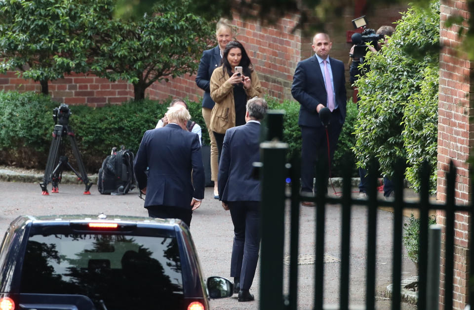 Britain's Prime Minister Boris Johnson, left, arrives at Stormont House in Belfast during a visit to Northern Ireland, Wednesday July 31, 2019. Northern Ireland, as part of the UK, has an invisible land border with the Republic of Ireland in Europe, which is the main stumbling block to a Brexit deal, and Johnson depends on Northern Irish political parties for his working majority in parliament. (Liam McBurney/PA via AP)