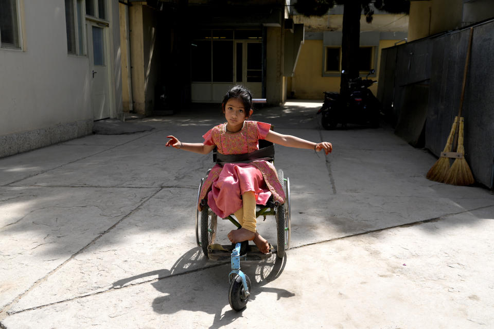 FILE - An Afghan polio victim makes her way in a wheelchair in the International Committee of the Red Cross (ICRC) physical rehabilitation center in Kabul, Afghanistan, May 16, 2022. In a surprising twist in the decades-long effort to eradicate the virus, authorities in Jerusalem, New York and London have discovered evidence that polio is spreading there. The source of the virus? The oral vaccine itself. For years, global health officials have used an oral vaccine in an attempt to wipe out polio from its last remaining strongholds in countries including Afghanistan, Pakistan and Nigeria. (AP Photo/Ebrahim Noroozi, File)