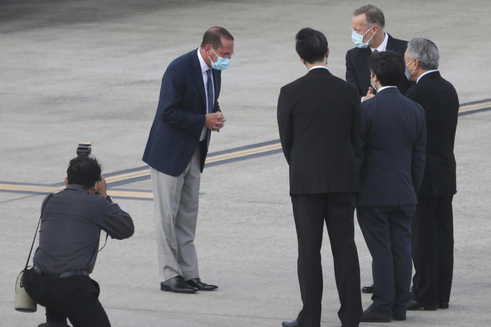 U.S. Health and Human Services Secretary Alex Azar, second left, greets Taiwanese officers as he arrives at Taipei Songshan Airport in Taipei, Taiwan, Sunday, Aug. 9, 2020. Azar arrived in Taiwan on Sunday in the highest-level visit by an American Cabinet official since the break in formal diplomatic relations between Washington and Taipei in 1979. (AP Photo/Chiang Ying-ying)