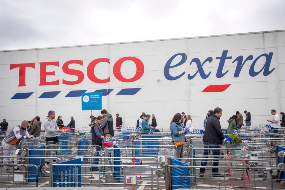 Customers queue outside a Tesco Extra store (PA Archive)