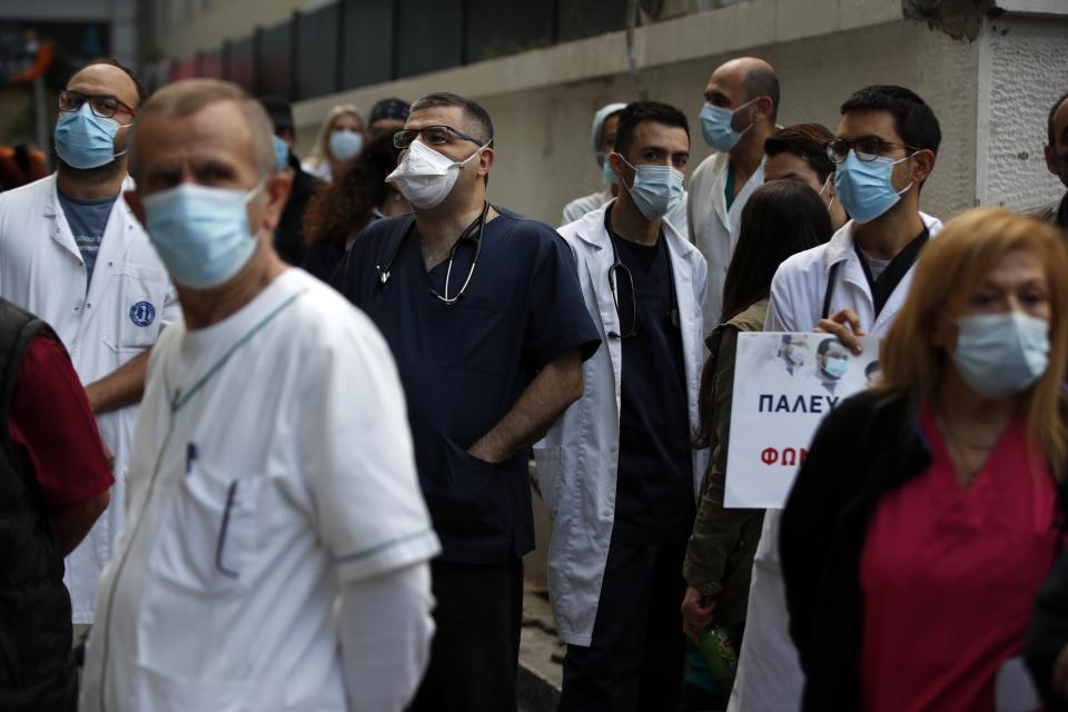 Health workers wearing face masks to protect against the spread of the coronavirus, take part in a protest at Evangelismos hospital in Athens, Thursday, Nov. 12, 2020. State health workers' union staged protests at several hospitals around the country to demand more hiring. Greece has imposed a nationwide nightly curfew as the number of COVID-19 cases in the country continues to surge despite a lockdown. (AP Photo/Thanassis Stavrakis)