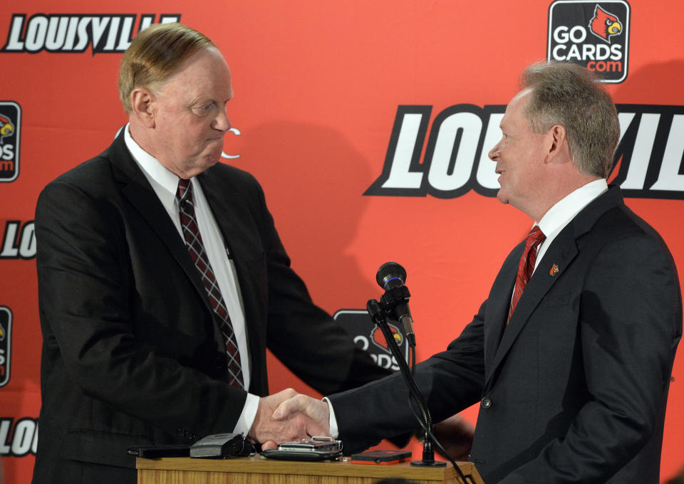 University of Louisville President Dr. James R. Ramsey, left, greets Bobby Petrino following he announcement of his hiring as the university's new NCAA college football coach Thursday, Jan. 9, 2014, at Papa John's Cardinal Stadium in Louisville, Ky. (AP Photo/Timothy D. Easley)