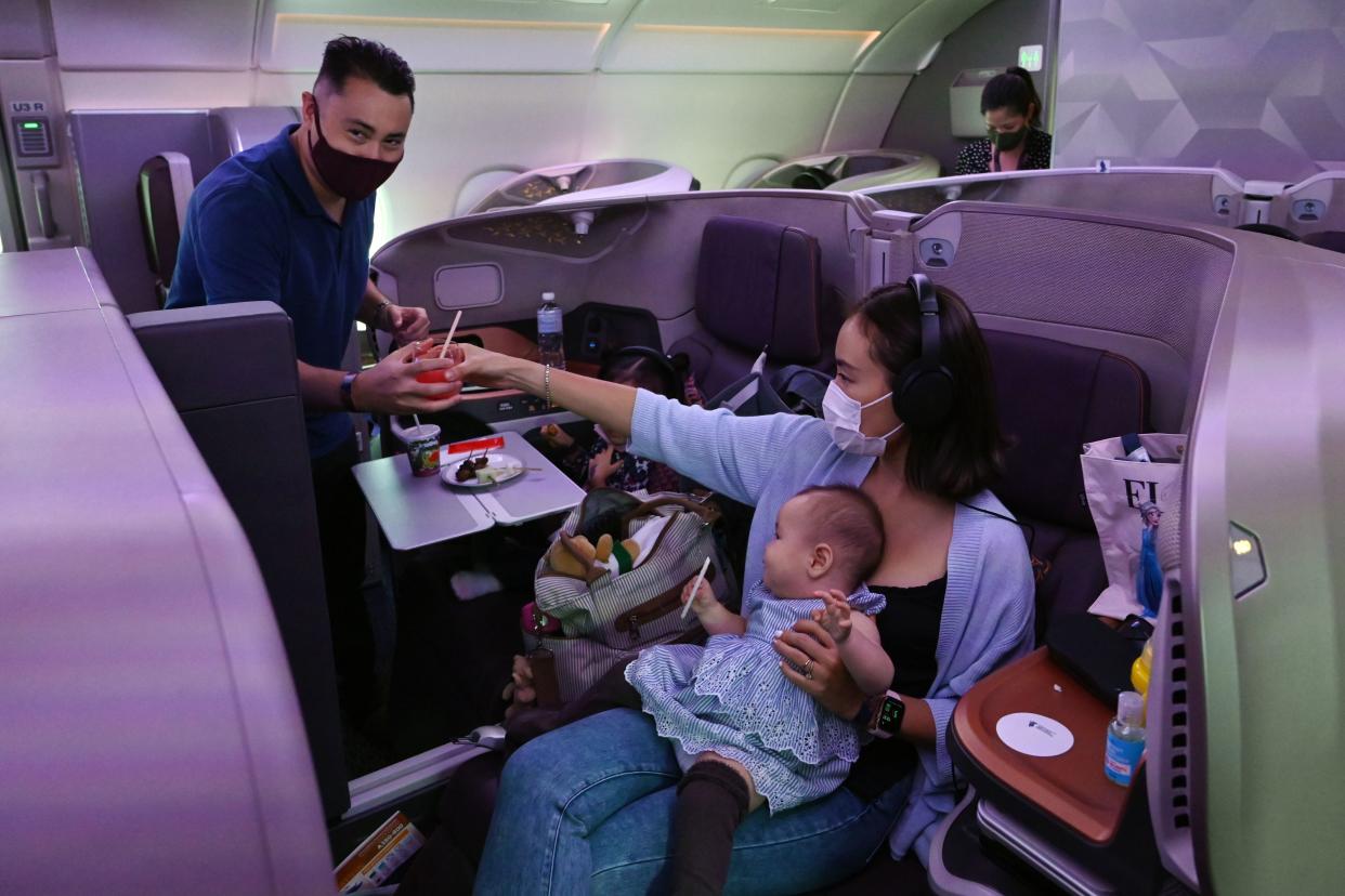 A couple and their children dine in business class during the inaugural lunch at Restaurant A380 @Changi onboard a Singapore Airlines Airbus A380 plane at Changi International Airport in Singapore on October 24, 2020. (Photo by ROSLAN RAHMAN / AFP) (Photo by ROSLAN RAHMAN/AFP via Getty Images)