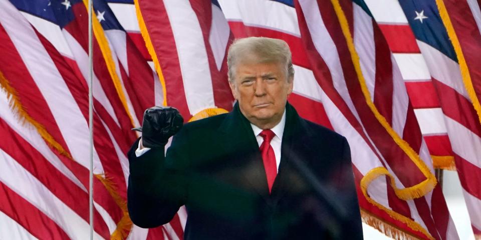 Donald Trump speaking in front of American flags