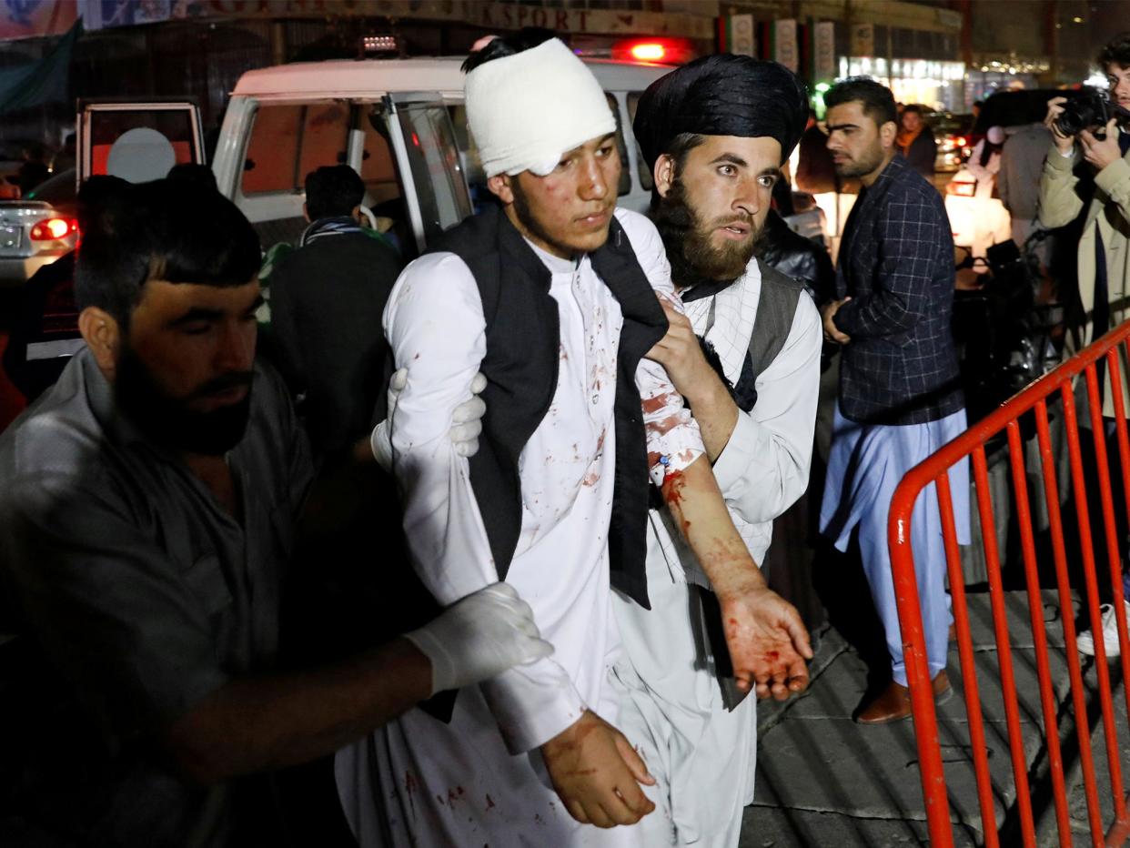 Men help one of the injured after the blast in a large wedding hall: Reuters