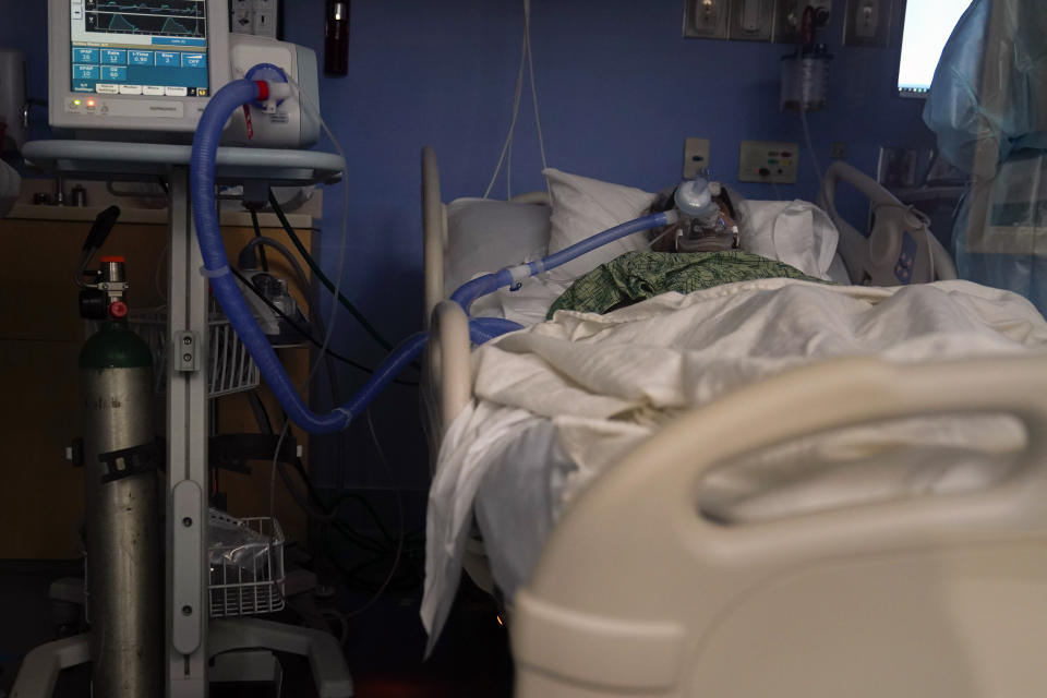 A COVID-19 patient, placed on a ventilator, rests at St. Joseph Hospital in Orange, Calif. Thursday, Jan. 7, 2021. California health authorities reported Thursday a record two-day total of 1,042 coronavirus deaths as many hospitals strain under unprecedented caseloads. (AP Photo/Jae C. Hong)