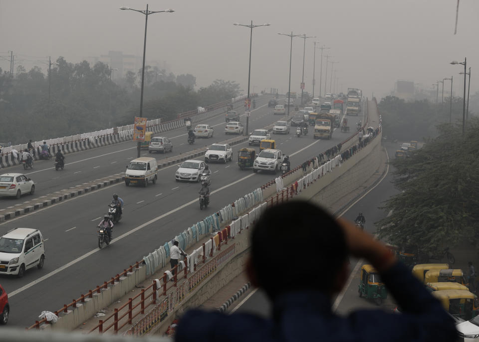 An Indian boy looks as city's sky line is seen enveloped in thick smog in New Delhi, India, Thursday, Nov. 14, 2019. Schools in India's capital have been shut for Thursday and Friday after air quality plunged to a severe category for the third consecutive day, enveloping New Delhi in a thick gray haze of noxious air. (AP Photo/Manish Swarup)