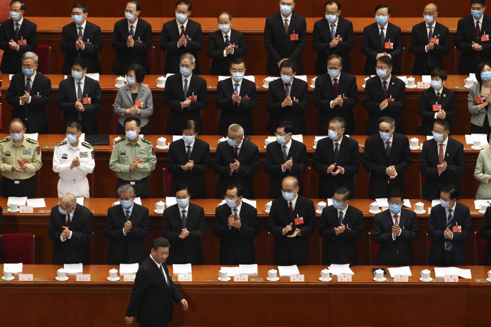 FILE - In this May 22, 2020, file photo, delegates applaud as President Xi Jinping arrives for the opening session of China's National People's Congress (NPC) at the Great Hall of the People in Beijing. (AP Photo/Ng Han Guan, Pool, File)