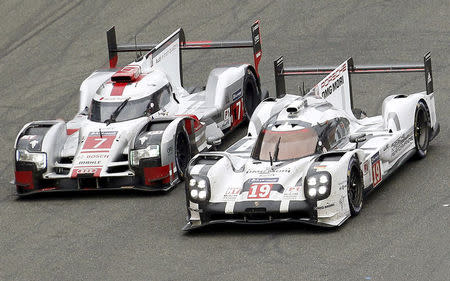 Nick Tandy of Britain drives his Porsche 919 Hybrid number 19 (R) ahead the Audi R18 e-tron quattro number 7 driven by Marcel Fassler of Switzerland, during the Le Mans 24 Hours sportscar race in Le Mans, central France June 14, 2015. REUTERS/Regis Duvignau/File Photo