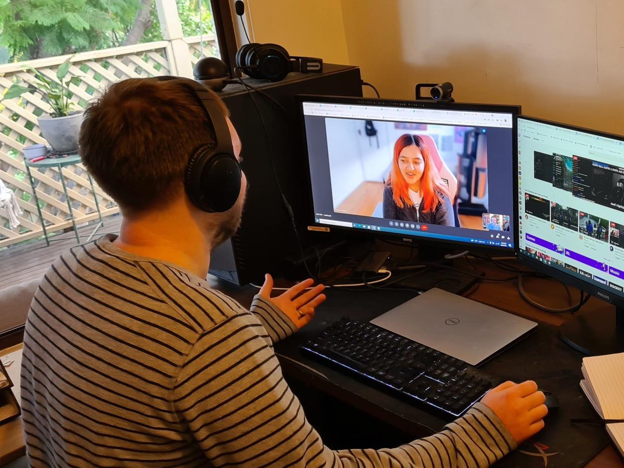 twitch exec lewis mitchell sits at home desk with headphones on