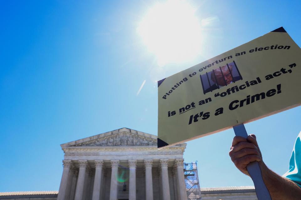 A person holds a placard outside the Supreme Court, after justices rule on former President and Republican presidential candidate Donald Trump's bid for immunity from federal prosecution for 2020 election subversion in Washington, on July 1, 2024.