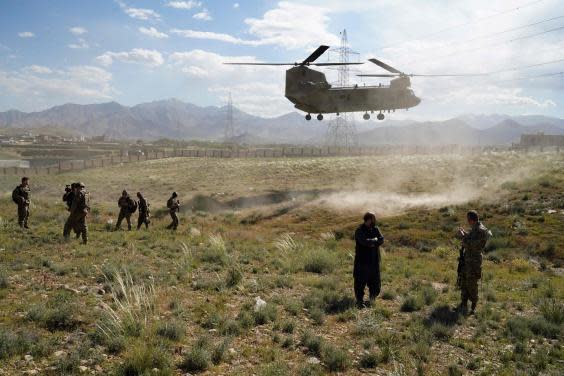 A US military Chinook helicopter lands on a field outside the governor's palace during a visit by the commander of US and NATO forces in Afghanistan, in Maidan Shar, capital of Wardak province (AFP via Getty Images)