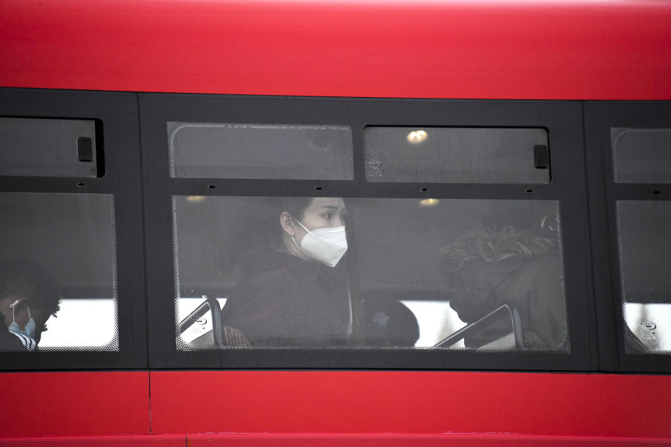 A woman wears a face mask as she sits on a bus, in London, Wednesday, Oct. 7, 2020. Like other countries in Europe, the U.K. has seen rising coronavirus infections over the past few weeks, which has prompted the government to announce a series of restrictions, both nationally and locally, to keep a lid on infections. (AP Photo/Alberto Pezzali)