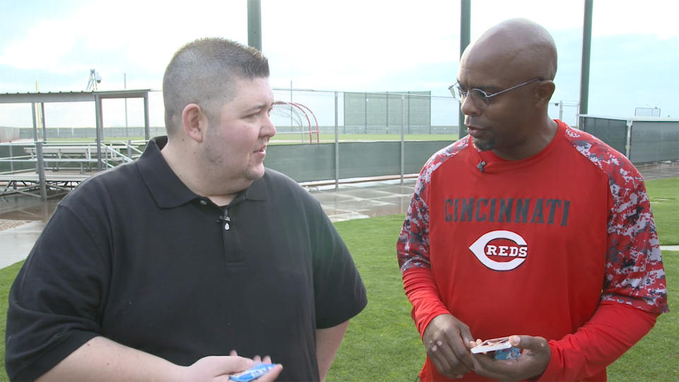 Delino DeShields, now a Triple-A manager for the Reds, opening 25-year-old baseball cards. (Yahoo Sports)