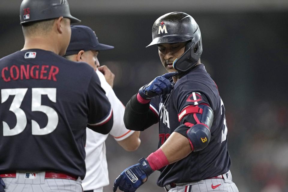 Minnesota Twins' Donovan Solano, right, points to his shoulder after hitting a two-run single against the Houston Astros during the third inning of a baseball game Wednesday, May 31, 2023, in Houston. (AP Photo/David J. Phillip)