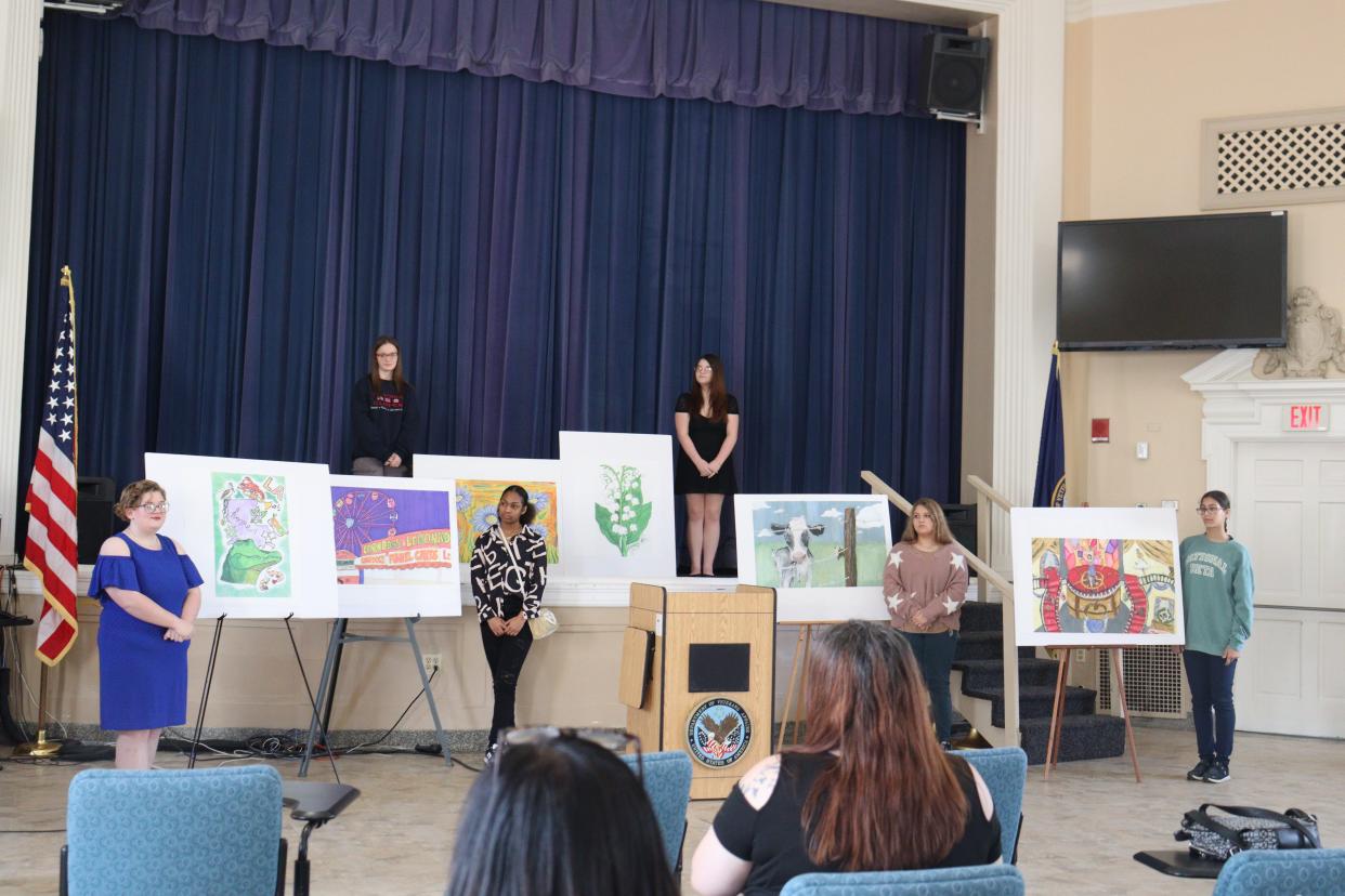 Students stand beside the pieces they painted and that were selected to be displayed as wallpaper at a mental-health unit at the Alexandria Veterans Affairs Medical Center in Pineville.
