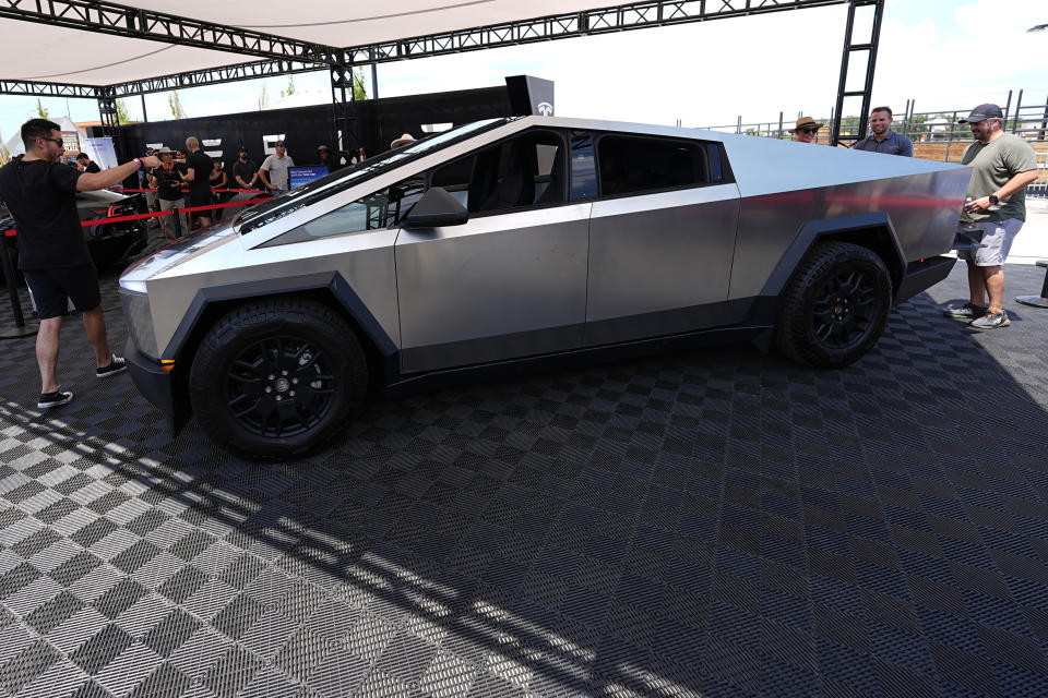 Visitors look over a 2024 Cybertruck in the Tesla display at the Electrify Expo, Sunday, July 14, 2024, in north Denver. The exposition was making its first stop in Denver as part of a countrywide effort to showcase the latest in a wide array of electric brands ranging from cars and trucks to bicycles and even skateboards. (AP Photo/David Zalubowski)