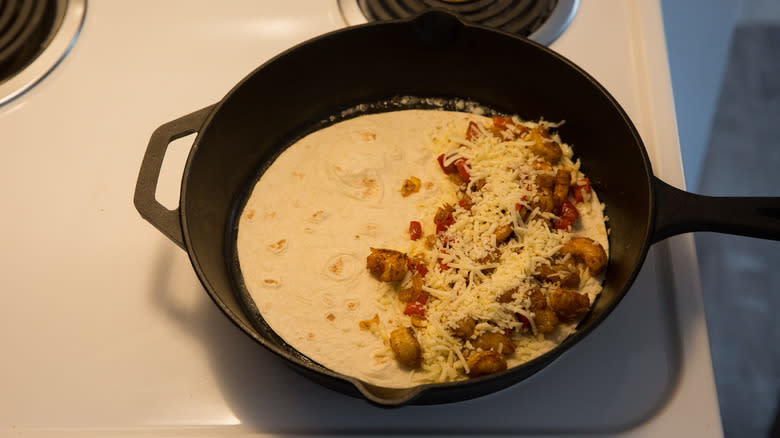 filled tortilla cooking in pan 