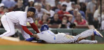 Boston Red Sox third baseman Rafael Devers, left, tags out Kansas City Royals' Billy Hamilton, right, who tried to advance to third on a flyout during the fourth inning of a baseball game at Fenway Park in Boston, Wednesday, Aug. 7, 2019. (AP Photo/Charles Krupa)