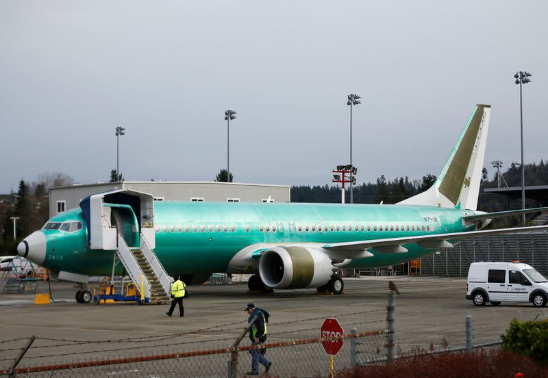 FILE PHOTO: Employees walk past a Boeing 737 Max aircraft at Boeing's 737 Max production facility in Renton
