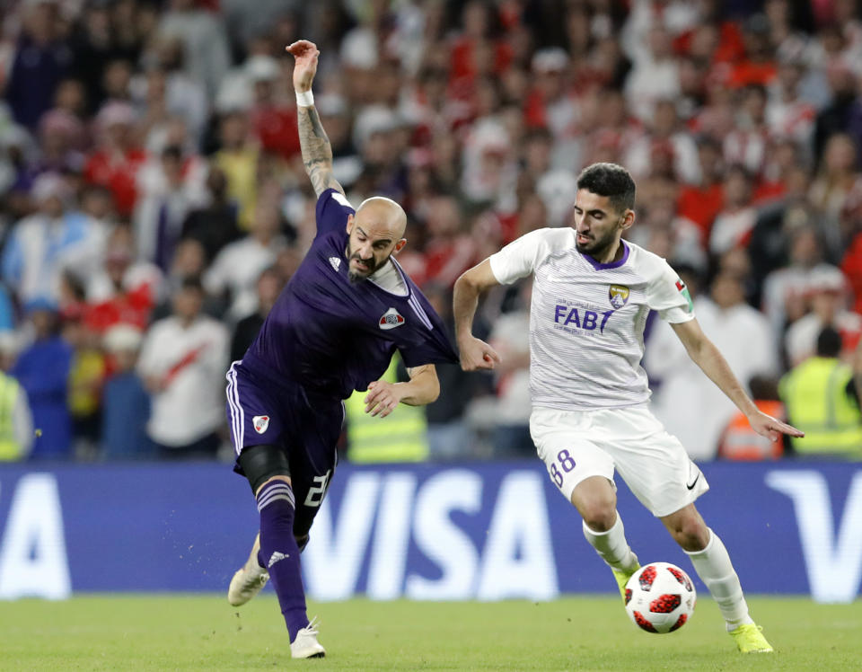 Argentina's River Plate Javier Pinola,left, and Emirates's Al Ain Yahia Nader run for the ball during the Club World Cup semifinal soccer match between Al Ain Club and River Plate at the Hazza Bin Zayed stadium in Al Ain, United Arab Emirates, Tuesday, Dec. 18, 2018. (AP Photo/Hassan Ammar)