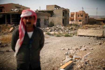 A yazidi man stands in front of destroyed houses in Sinjar region, Iraq August 2, 2017. REUTERS/Suhaib Salem