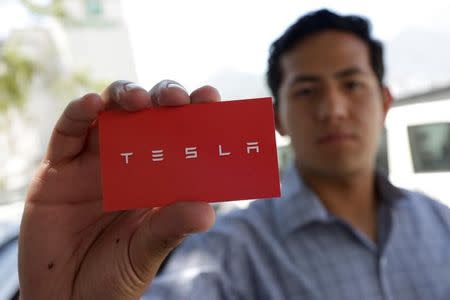 A job seeker shows off a card after leaving his documents and arranging a meeting with recruiters from Tesla at the hotel where the electric vehicle maker is holding a recruiting event for its California factory, in the municipality of San Pedro Garza, neighbouring Monterrey, May 5, 2017. REUTERS/Daniel Becerril