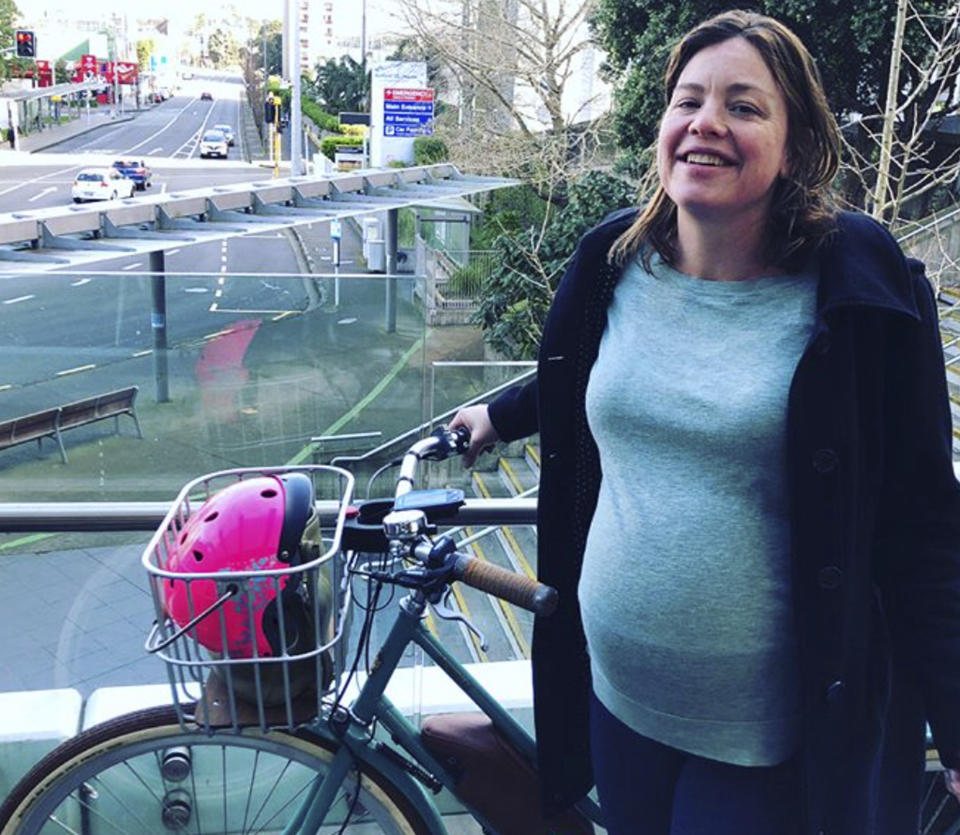 In this Sunday, Aug. 19, 2018, Instagram photo released by New Zealand’s Minister for Women Julie Anne Genter, Genter pregnant with her bicycle pose on an overpass outside Auckland City Hospital in Auckland, New Zealand. Genter said she decided to ride to the hospital on her electric bicycle because it was a beautiful morning and there wasn't enough room in the car for her support crew. (Peter Nunns/Julie Anne Genter via AP)