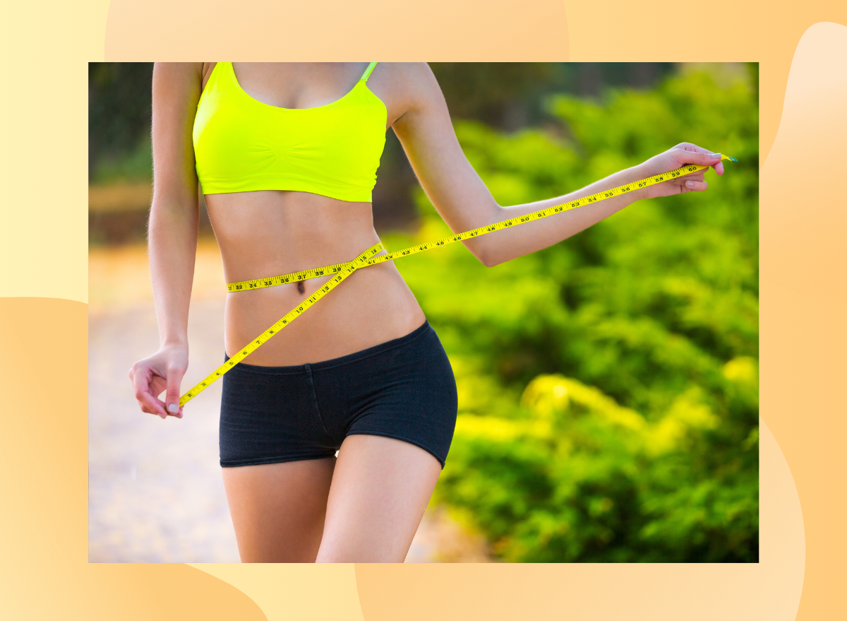 fit woman close-up measuring waistline outside