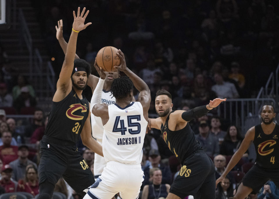 Memphis Grizzlies' GG Jackson (45) attempts a shot as Cleveland Cavaliers' Jarrett Allen (31) defends and the Cavaliers' Max Strus (1) looks on during the first half of an NBA basketball game in Cleveland, Wednesday, April 10, 2024. (AP Photo/Phil Long)