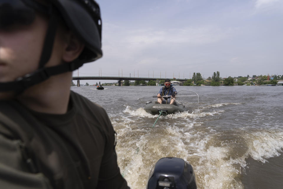 An animal rescue team search for animals in flooded area after the dam collapse in Kherson, Ukraine, Thursday, June 8, 2023. (AP Photo/Vasilisa Stepanenko)