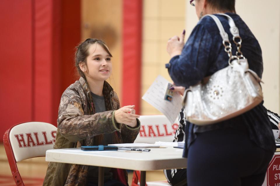 Alyssa Ross, 17, helps check in voters at the Halls High School polling station on May 3.