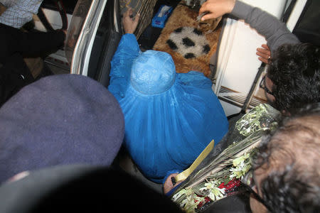 Officials escort Sharbat Gula (C), the green-eyed Afghan woman who became a symbol of her country's wars 30 years ago when her photo as a girl appeared on the cover of National Geographic magazine, as she enters a car to leave a hospital in Peshawar, Pakistan, November 9, 2016. REUTERS/Fayaz Aziz