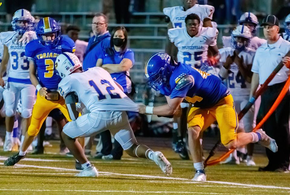 Austin, TX: Pflugerville Panthers running back Jake Iloka (12) runs is stopped by Anderson Trojans middle linebacker Iv Webb (44) during the fourth quarter at the District 11-5A football game on Thursday, Sept. 23, 2021, at Nelson Field.