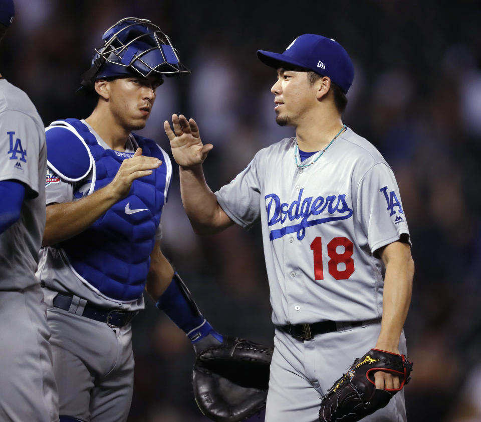 Los Angeles Dodgers relief pitcher Kenta Maeda, right, and catcher Austin Barnes congratulate one another after the Dodgers' 4-2 win in a a baseball game against the Colorado Rockies on Friday, Sept. 7, 2018, in Denver. (AP Photo/David Zalubowski)