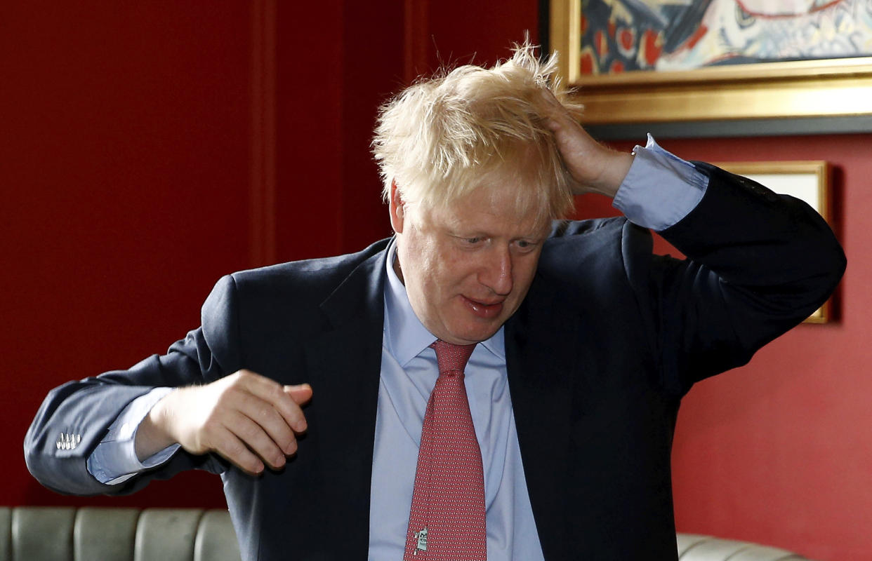 Conservative Party leadership candidate Boris Johnson gestures during a visit to Wetherspoons Metropolitan Bar in London, Wednesday July 10, 2019. (Henry Nicholls/Pool Photo via AP)